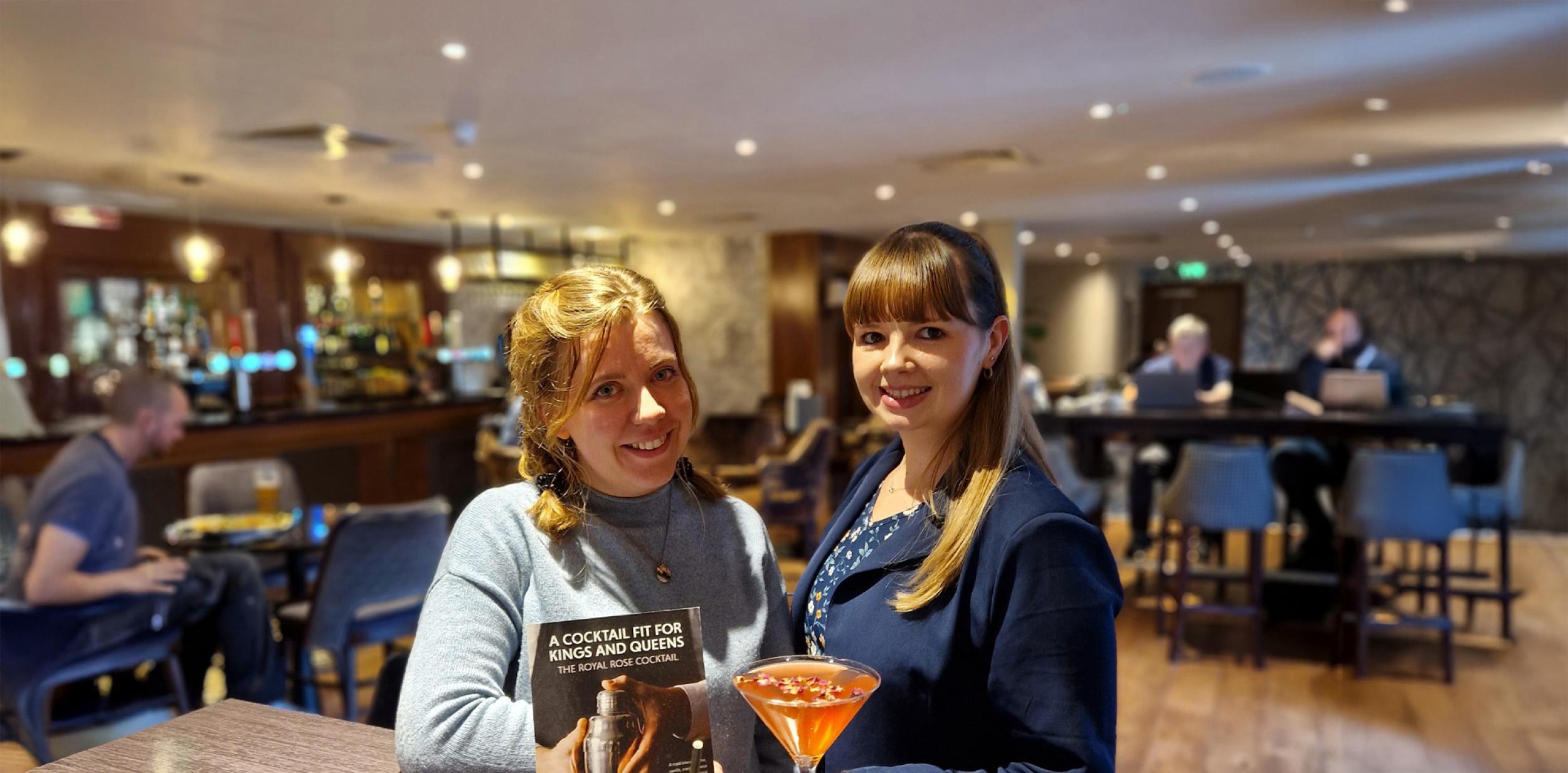 Two women smiling with cocktails