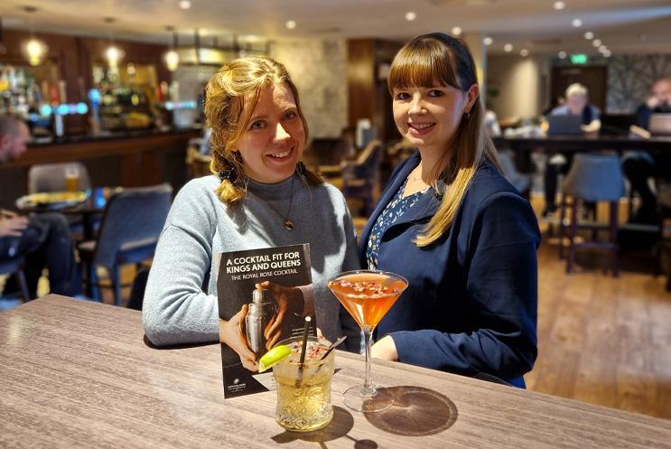 Two women smiling with cocktails